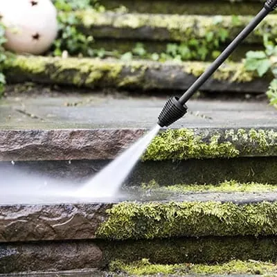 Jet d'eau haute pression nettoyant la mousse des marches d'un escalier extérieur en pierre (version carrée).
